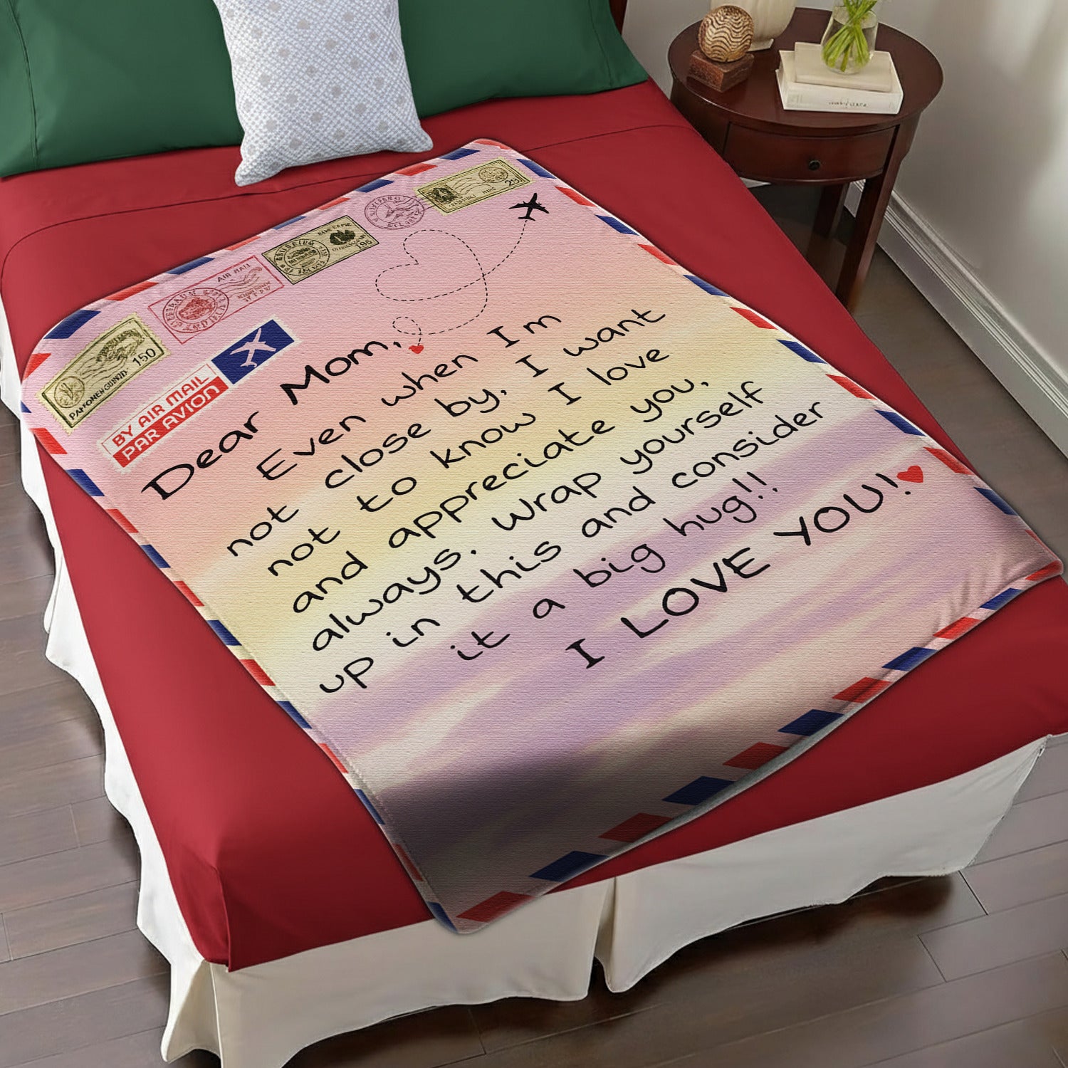 Airmail-style mom blanket with loving long-distance message displayed on a red and white bed — Discover heartfelt personal gifts at HerTender.com