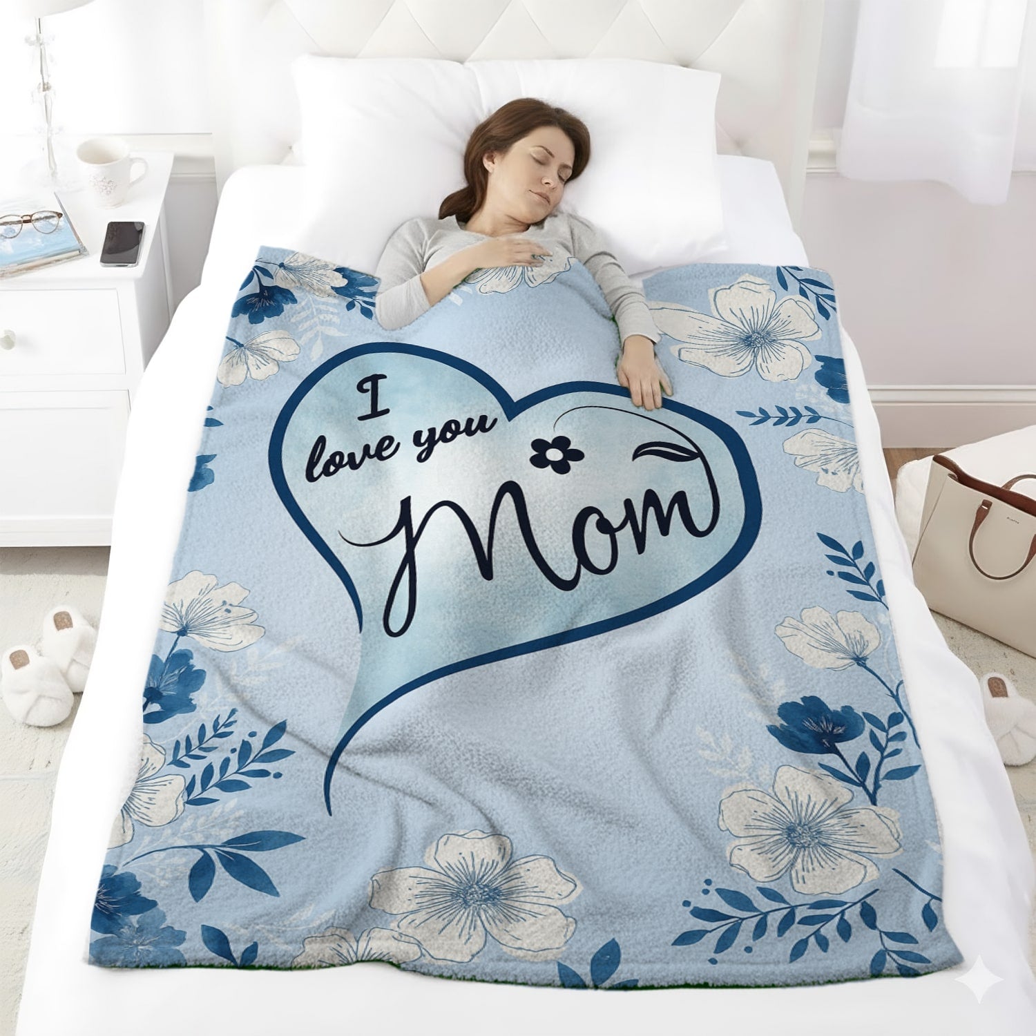 Woman sleeping under a blue floral mom blanket with heart design and loving message — Discover heartfelt personal gifts at HerTender.com