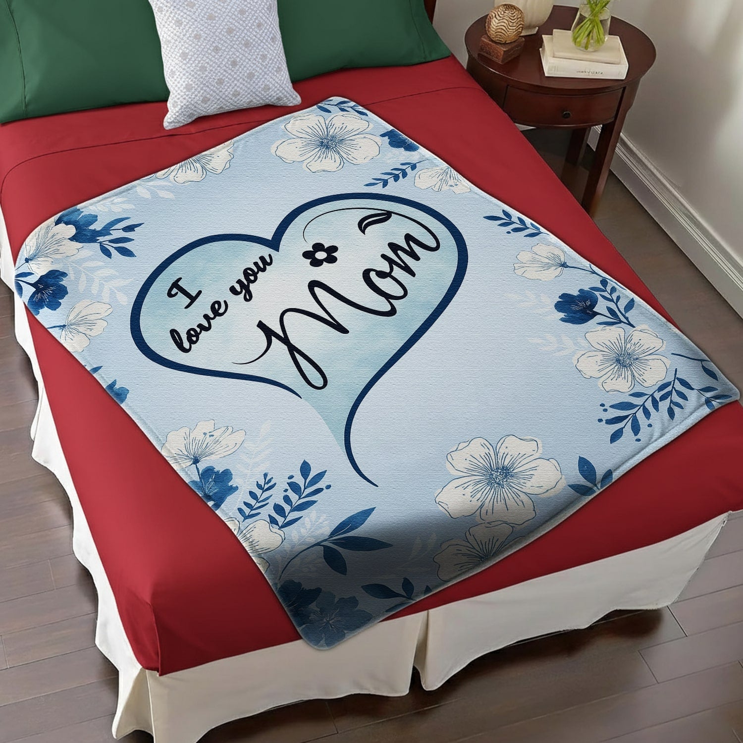 Blue floral mom blanket with heart design and loving message displayed on a red and white bed — Discover heartfelt personal gifts at HerTender.com