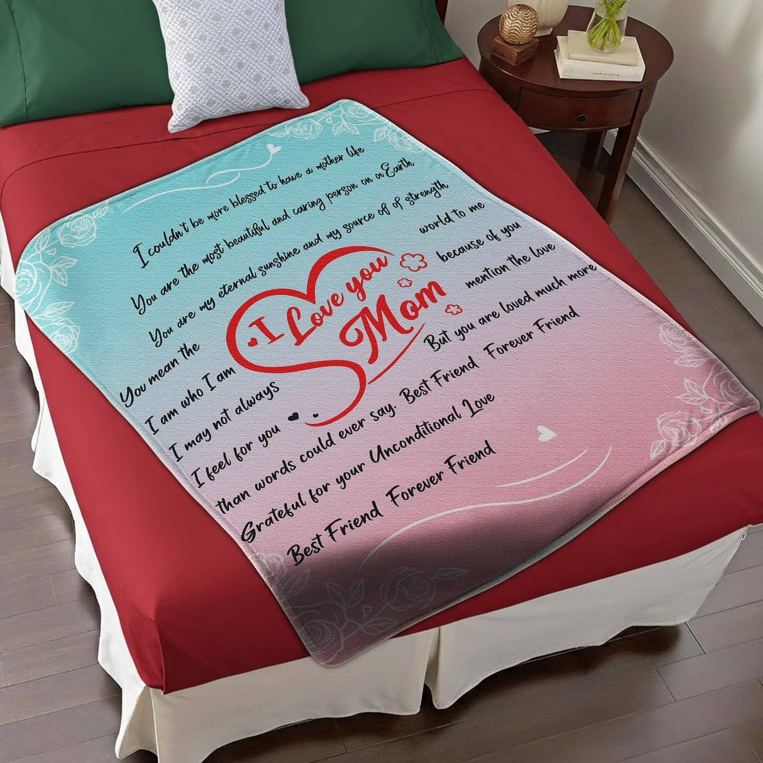 Pastel pink and blue mom blanket with red heart and loving message displayed on a red and white bed — Discover heartfelt personal gifts at HerTender.com