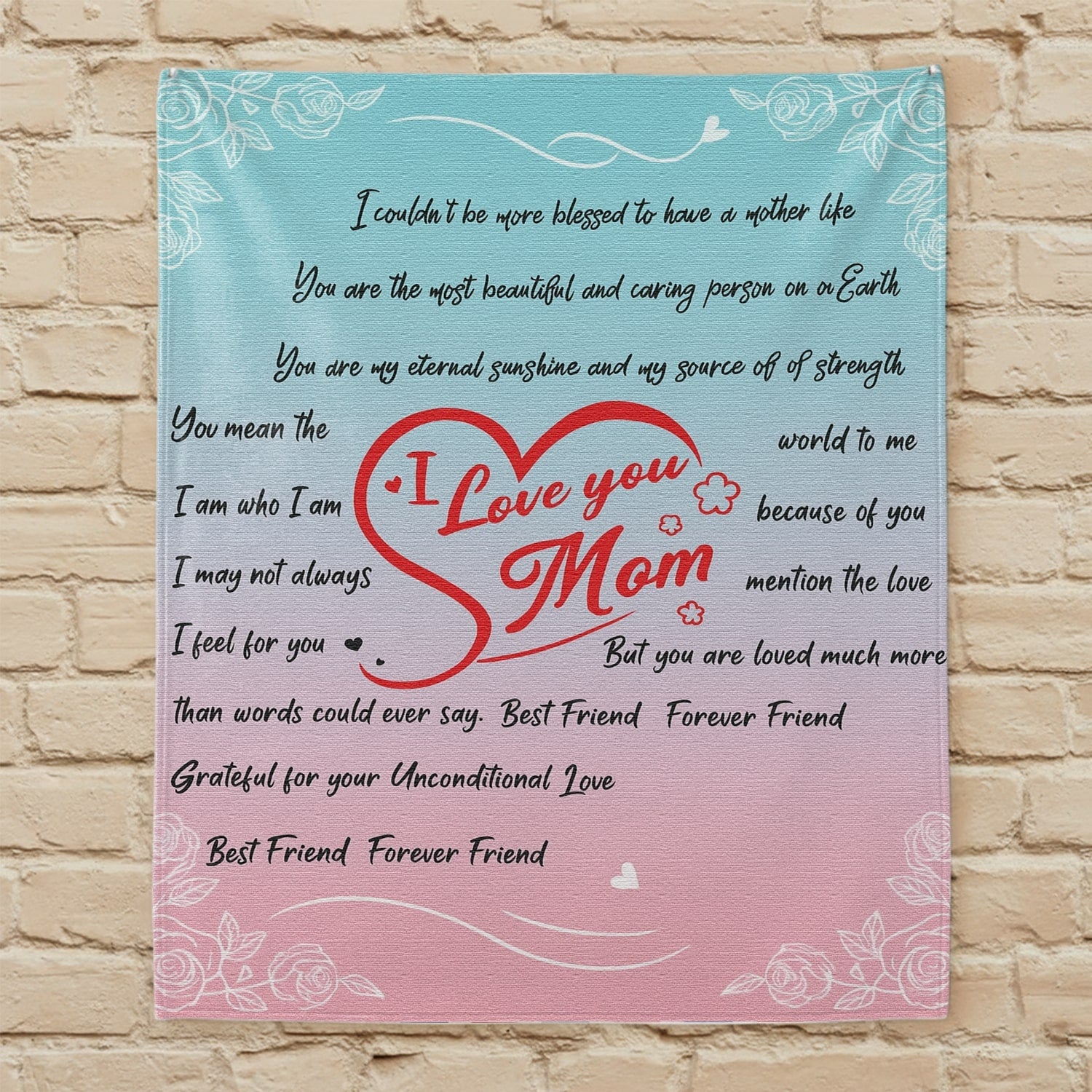 Pastel pink and blue mom blanket with red heart and loving message displayed on a beige brick wall — Discover heartfelt personal gifts at HerTender.com