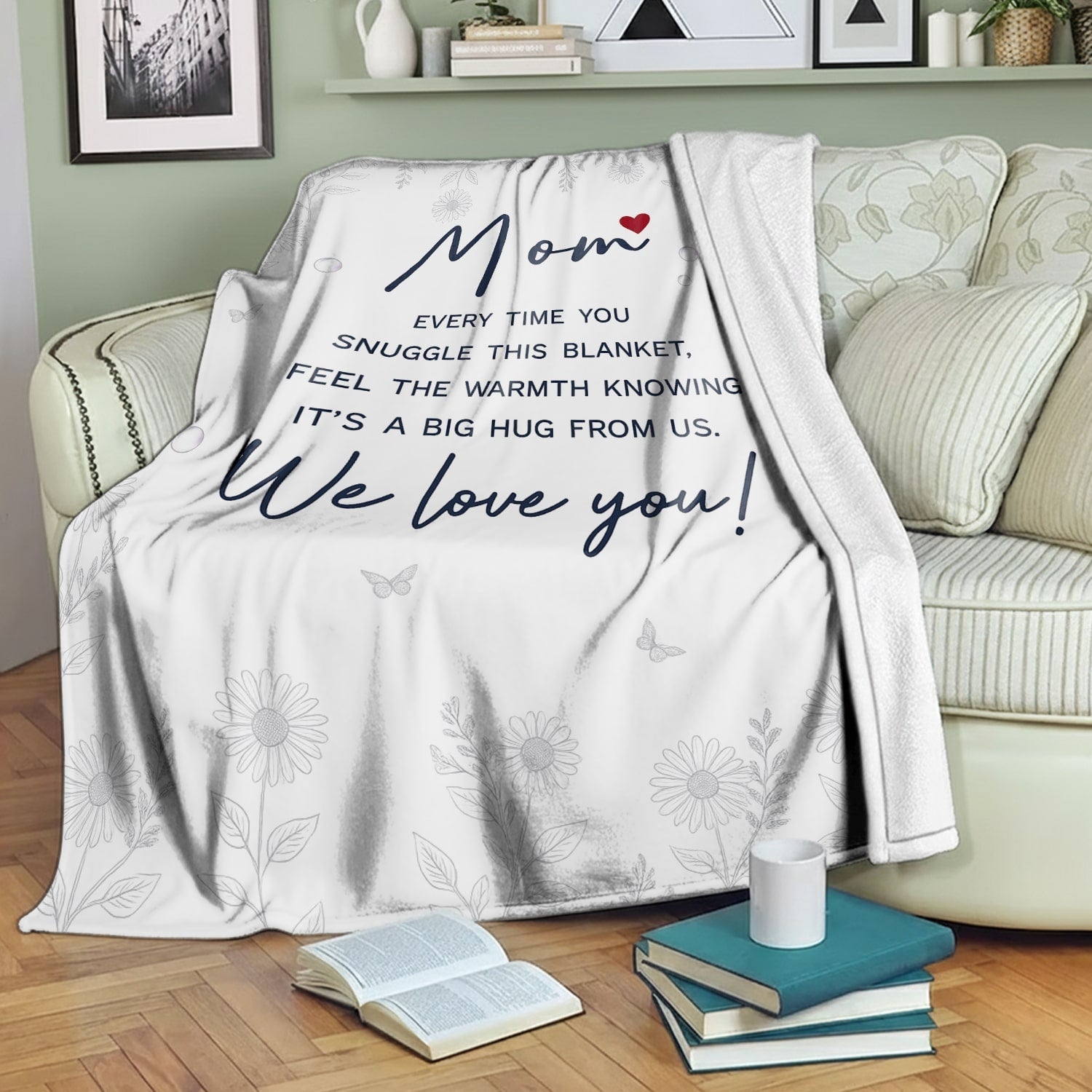White floral mom blanket with heartfelt message draped over a cozy green sofa — Discover heartfelt personal gifts at HerTender.com