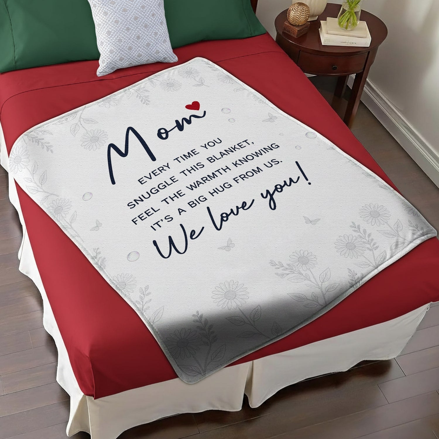 White floral mom blanket with heartfelt message displayed on a red and white bed — Discover heartfelt personal gifts at HerTender.com