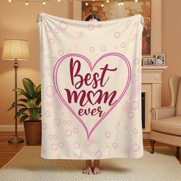 “Best Mom Ever” pink heart blanket in a cozy living room — wrap her in love with Personalized Gifts from HerTender.com.
