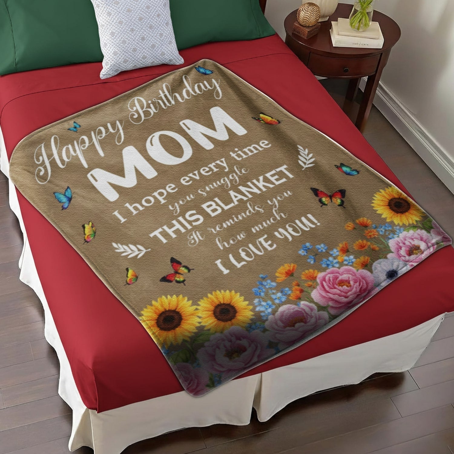 Birthday blanket for mom with butterflies and flowers neatly placed on a red bed, symbolizing personalized gifts — Discover heartfelt personalized gifts at HerTender.com.