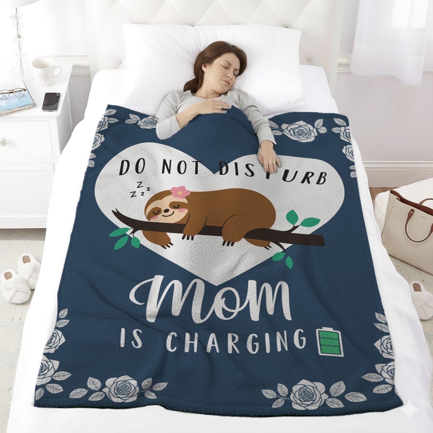 Woman sleeping under a navy blue blanket with a sloth and the quote “Do Not Disturb Mom Is Charging,” symbolizing cozy personalized gifts — Discover heartfelt personalized gifts at HerTender.com.