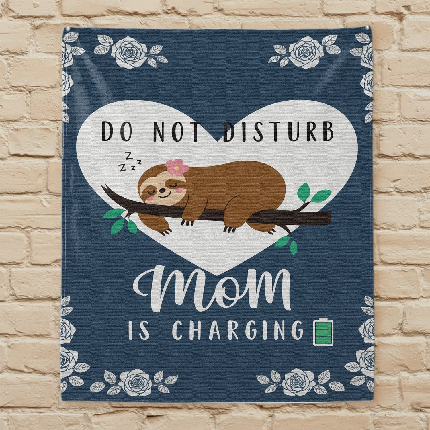 Do Not Disturb Mom Is Charging blanket with a sloth and floral design displayed against a beige brick wall, symbolizing personalized gifts — Discover heartfelt personalized gifts at HerTender.com.