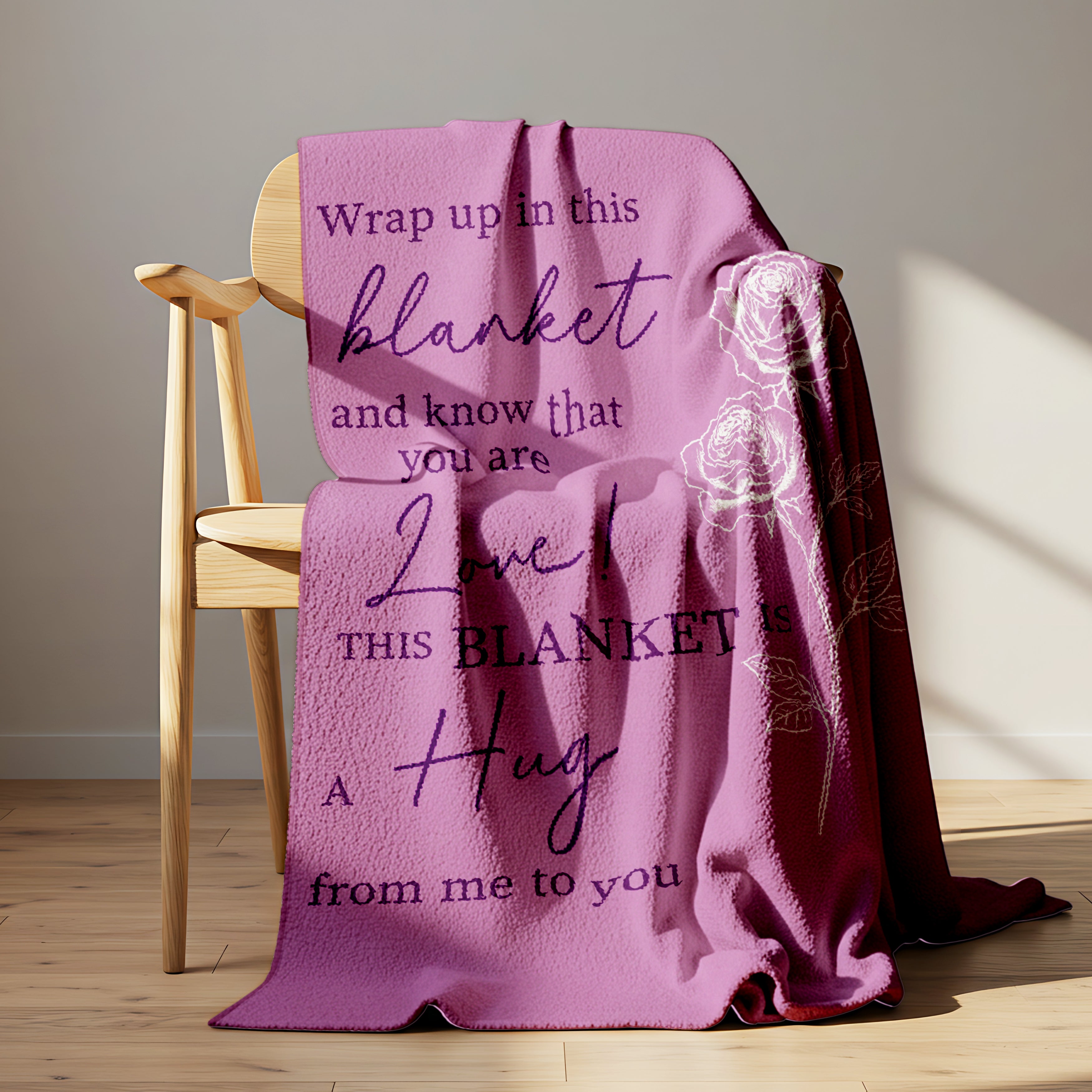 Lavender blanket with rose design and message “This blanket is a hug from me to you” draped over a wooden chair in sunlight, symbolizing heartfelt personalized gifts — Discover meaningful personalized gifts at HerTender.com.