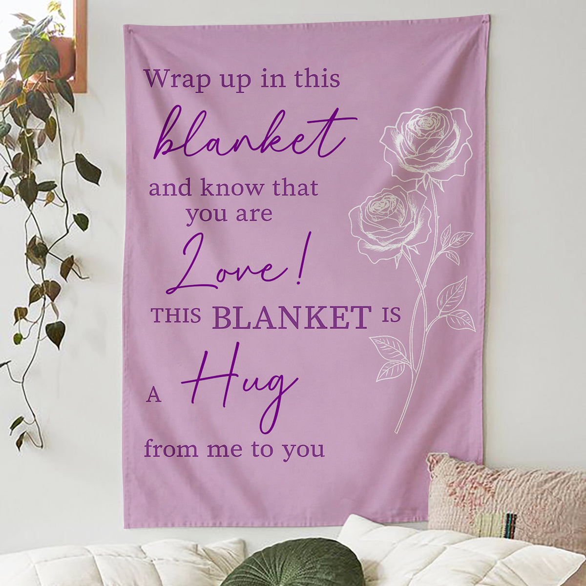 Lavender blanket with rose design and the quote “This blanket is a hug from me to you” hanging on a cozy bedroom wall, symbolizing heartfelt personalized gifts — Discover meaningful personalized gifts at HerTender.com.