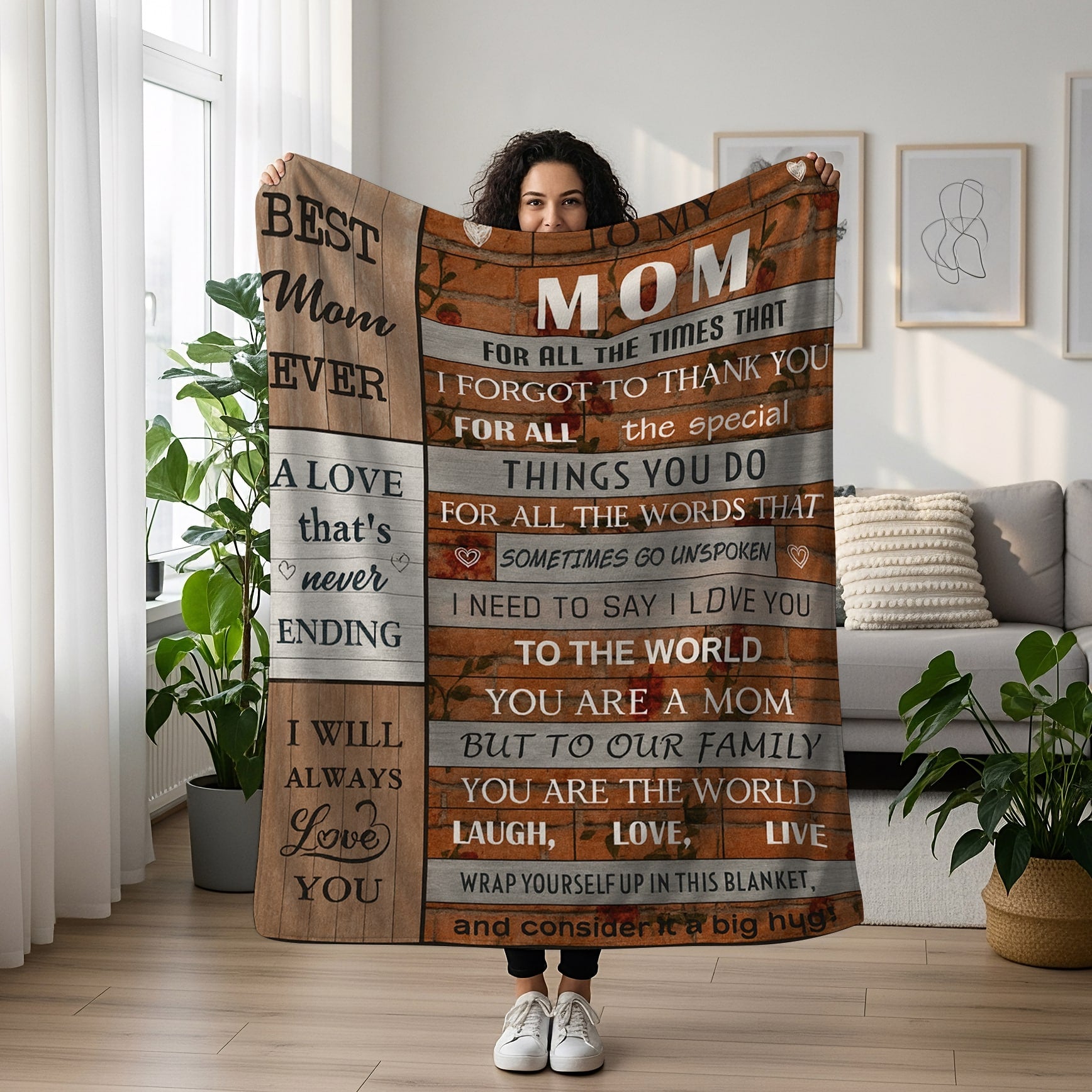 Woman holding a rustic wood-style blanket with the message “To the world you are a mom, but to our family you are the world,” symbolizing heartfelt personalized gifts — Discover meaningful personalized gifts at HerTender.com.
