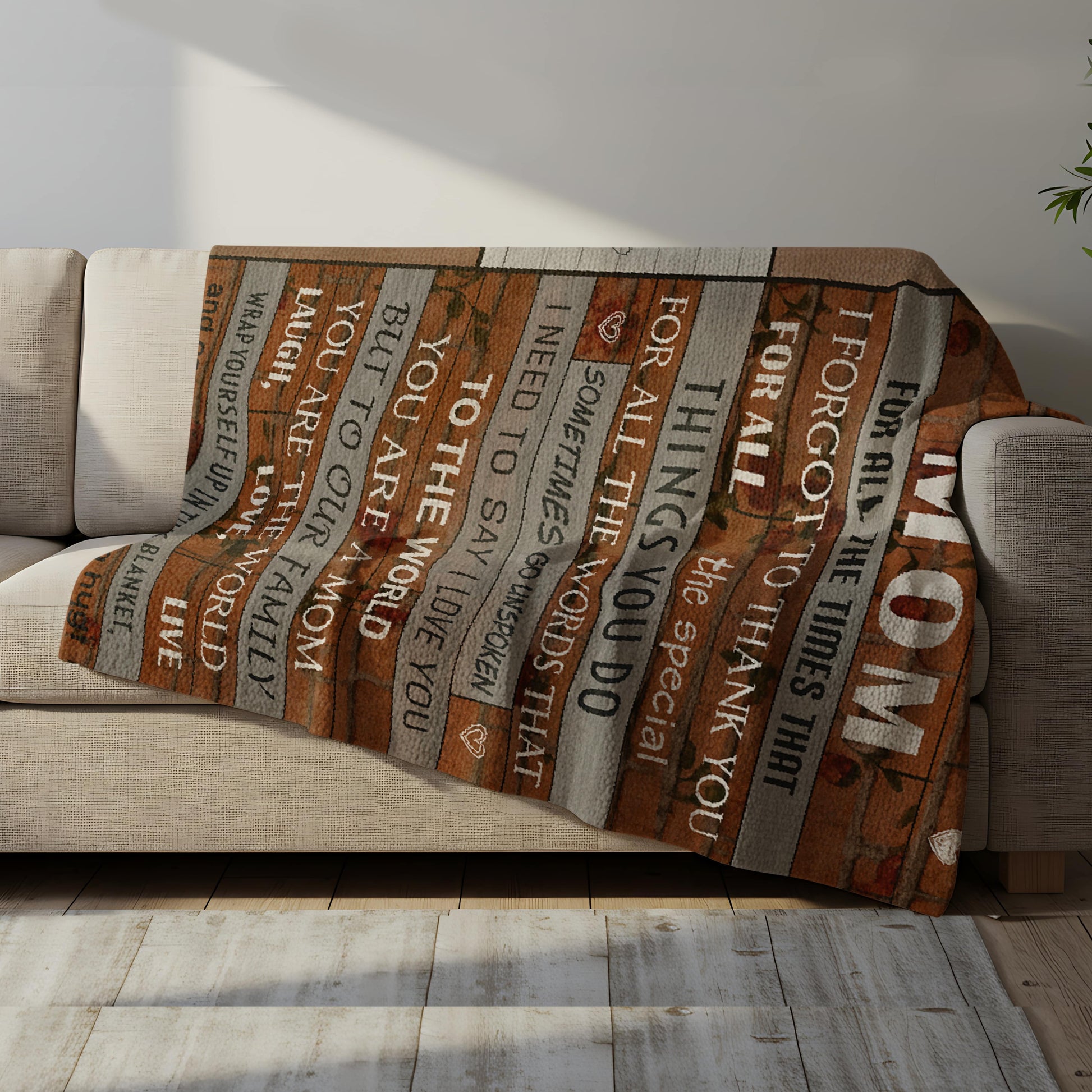 Rustic wood-style blanket with the message “To the world you are a mom, but to our family you are the world” draped over a cozy sofa, symbolizing heartfelt personalized gifts — Discover meaningful personalized gifts at HerTender.com.