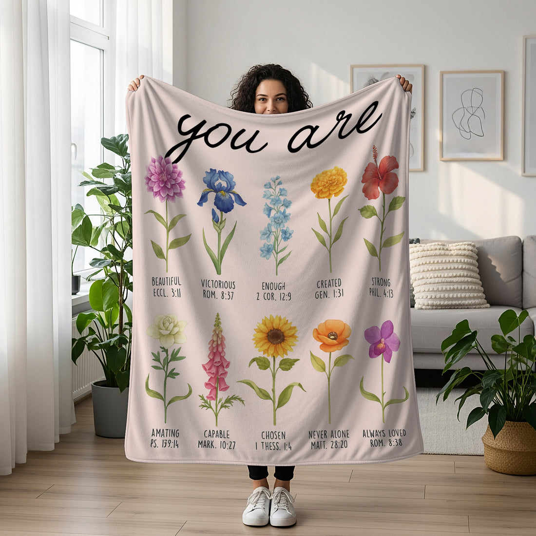 Woman holding a floral blanket with the words “You Are” and Bible verse affirmations, symbolizing faith-inspired personalized gifts — Discover heartfelt personalized gifts at HerTender.com.