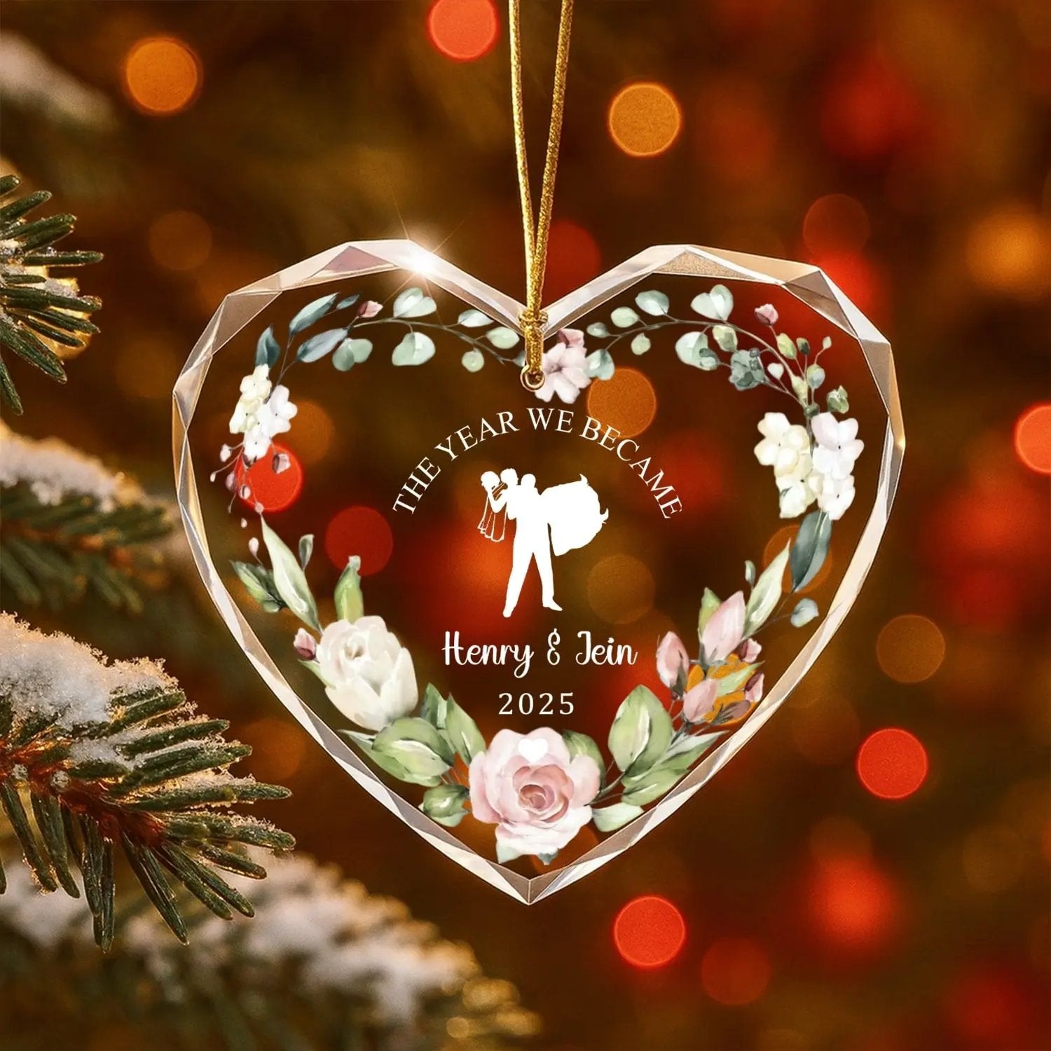Heart-shaped personalized glass ornament with floral design and bride-and-groom silhouette on a Christmas tree — Celebrate love with romantic personalized gifts from Hertender.com.