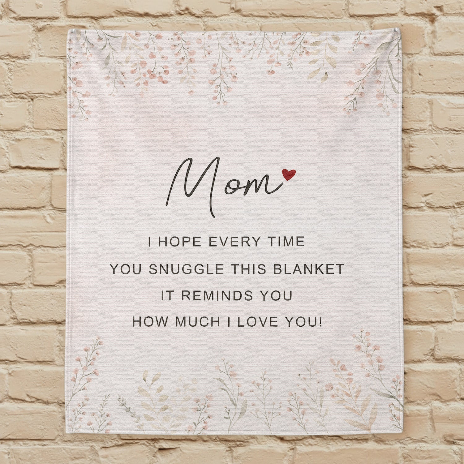 Personalized mom blanket with loving message hanging on a beige brick wall — Discover heartfelt personal gifts at HerTender.com