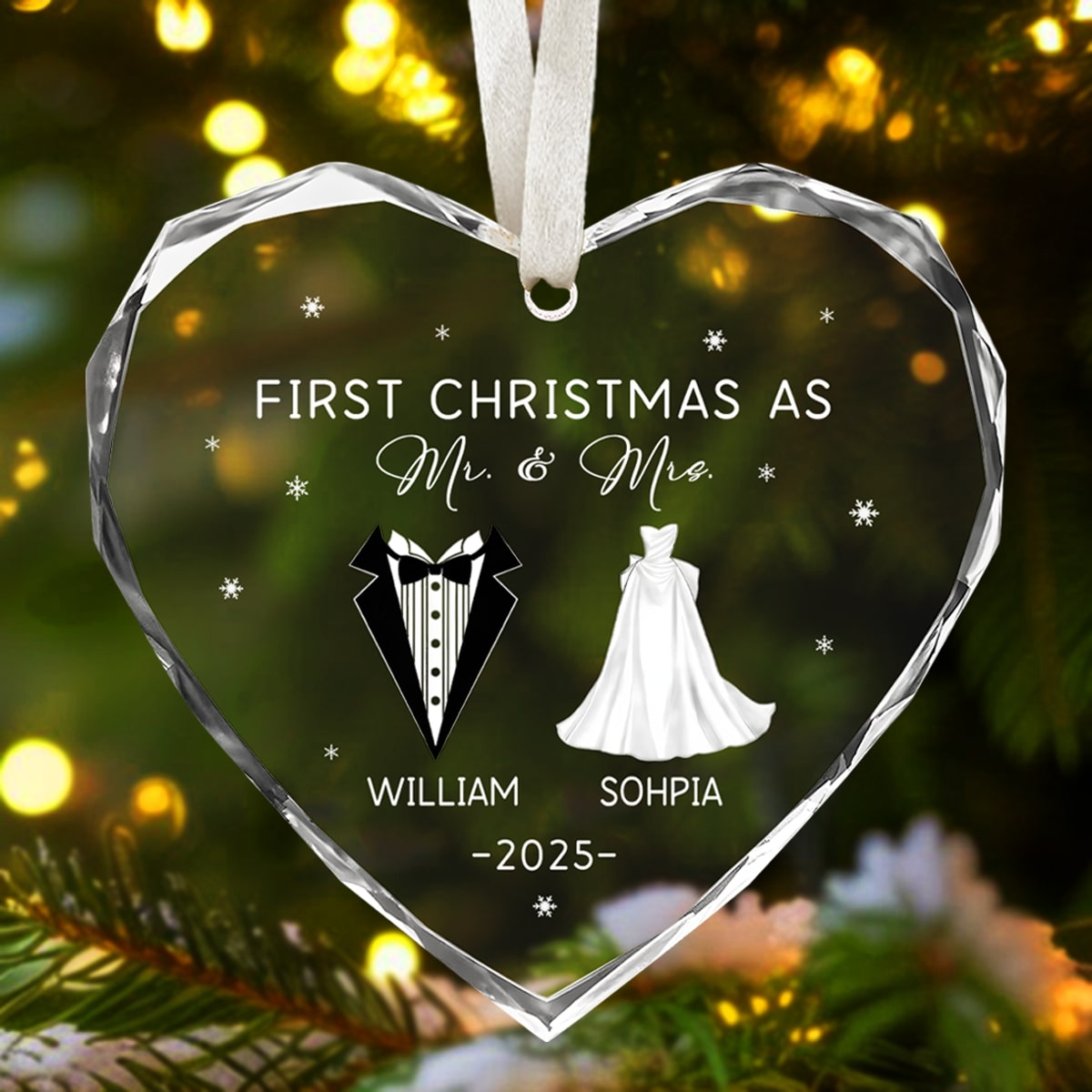 Heart-shaped glass ornament engraved “First Christmas as Mr. & Mrs.” glowing among Christmas tree lights — Discover meaningful personalized Christmas gifts at Hertender.com.