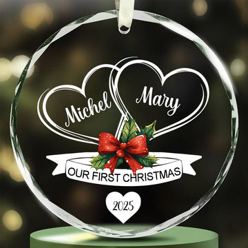 Round glass ornament with two engraved hearts and red bow reading “Our First Christmas 2025” — Discover romantic personalized Christmas gifts at Hertender.com.