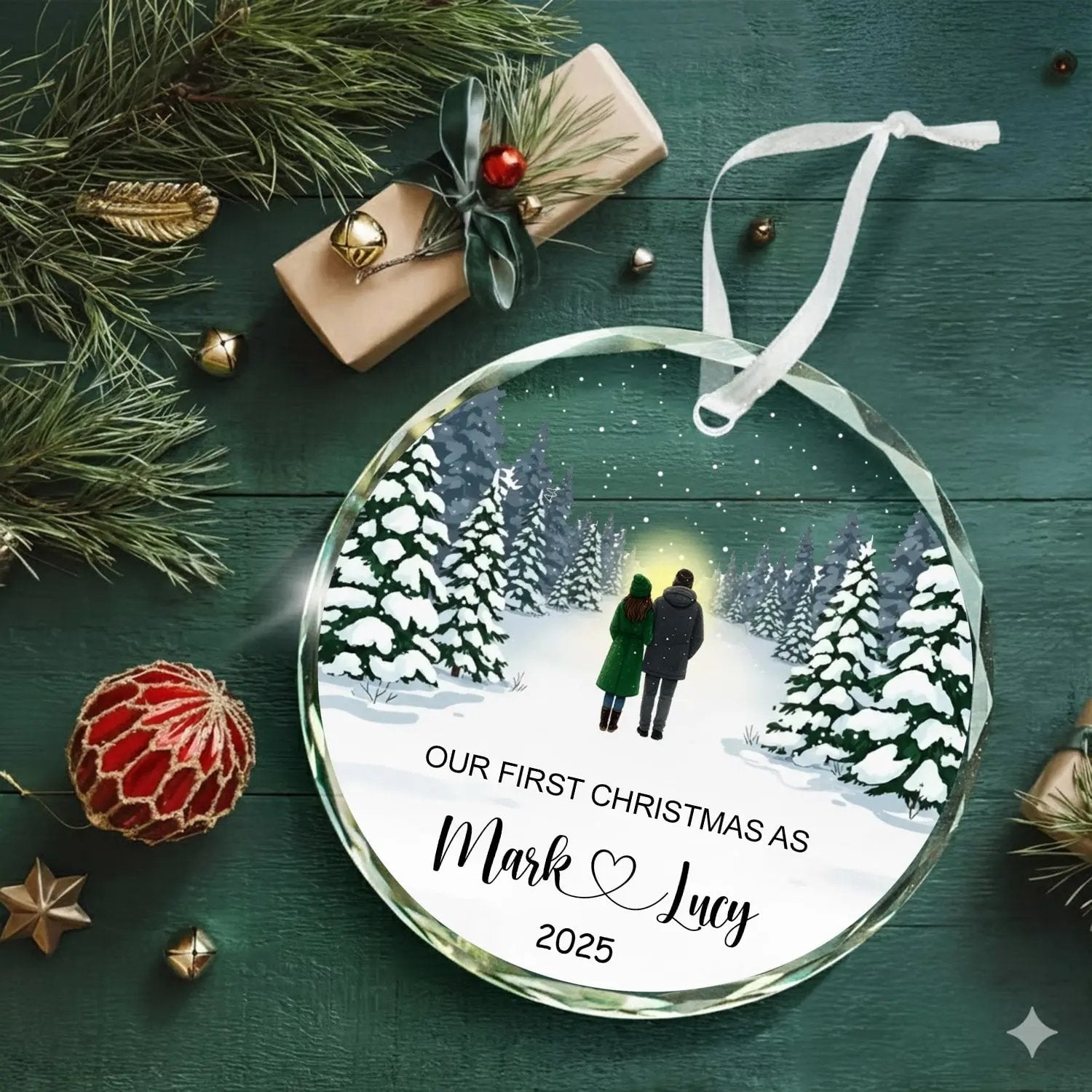Round personalized glass Christmas ornament with snowy forest couple design and text “Our First Christmas As Mark and Lucy 2025” — Discover romantic personalized gifts that celebrate love at Hertender.com.